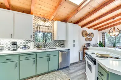 a kitchen with white cabinets and a wooden ceiling at 1 Mi to Pine Mountain Lake Marina Yosemite Cabin! in Groveland