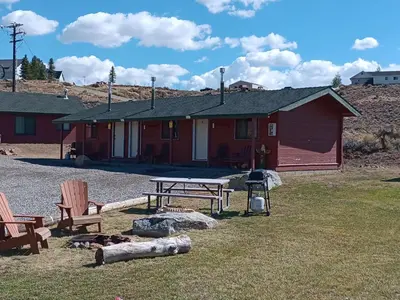 a cabin with a picnic table and chairs in front of it at Big Meadow Lodge in Bridgeport