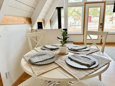 a white table with plates on it in a kitchen at Picturesque Yosemite A-Frame in Mariposa