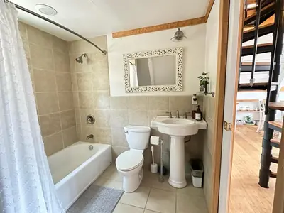 a bathroom with a toilet and a sink and a bath tub at Picturesque Yosemite A-Frame in Mariposa