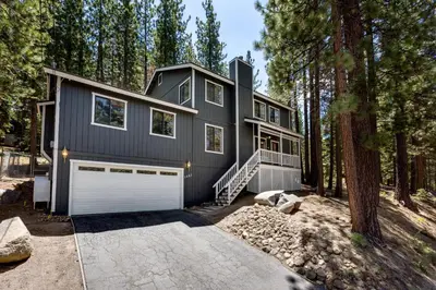 a house in the woods with a garage at Large Seasonal Rental South Lake Tahoe in South Lake Tahoe
