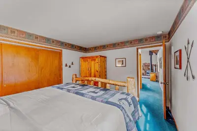 a bedroom with a bed and a wooden door at Near Northstar Wooded Retreat with Deck & Loft in Tahoe Vista