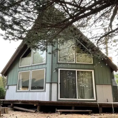 a green house with windows on the side of it at Spacious family home on the Meadow Monthly Only in South Lake Tahoe