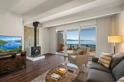 a living room with a couch and a tv and a fireplace at Newley remodeled, two story, two-bedroom condo nothing but Views of Lake Tahoe! in Incline Village