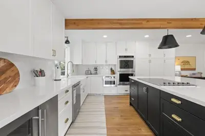a large kitchen with white cabinets and black appliances at Luxury Lake Home-The Bear Claw-Boat Slip-Sleeps 16 in Bass Lake