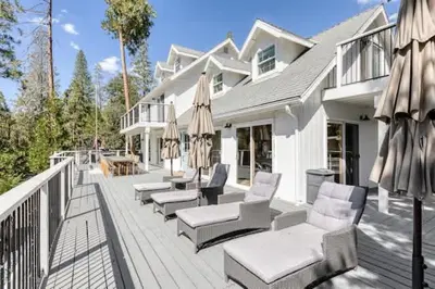 a deck with chairs and umbrellas on a house at Luxury Lake Home-The Bear Claw-Boat Slip-Sleeps 16 in Bass Lake