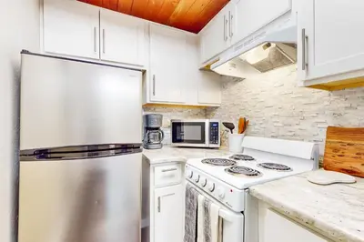 a kitchen with white cabinets and a stainless steel refrigerator at Mountain Serenity, near Ski, Golf, Casino, Lake in Stateline