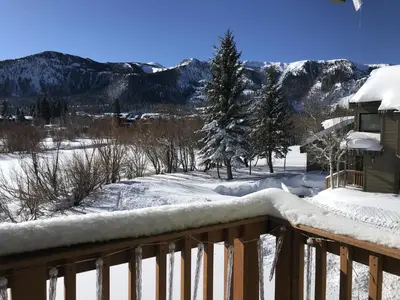 a snow covered balcony with a view of the mountains at Snowcreek II #220 condo in Mammoth Lakes