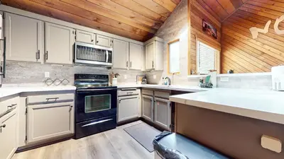 a kitchen with white cabinets and a wooden ceiling at Snowcreek II #220 condo in Mammoth Lakes