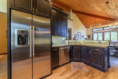 a kitchen with stainless steel appliances and wooden cabinets at Grand Townhome w/ Meadow Views; Private Garage in Mammoth Lakes