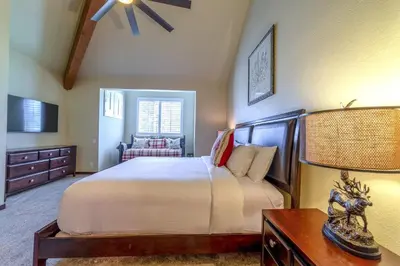a bedroom with a bed and a table with a lamp at Grand Townhome w/ Meadow Views; Private Garage in Mammoth Lakes