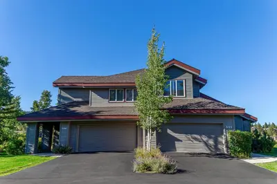 a blue house with a tree in the driveway at Grand Townhome w/ Meadow Views; Private Garage in Mammoth Lakes