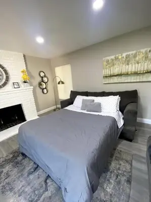 a bedroom with a large bed and a fireplace at Entire House in Old Fig Garden in Fresno