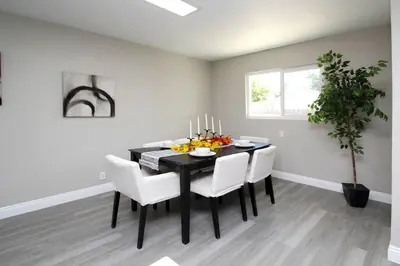 a dining room with a black table and white chairs at Entire House in Old Fig Garden in Fresno