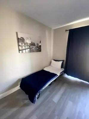 a small room with a bed with a blue blanket at Entire House in Old Fig Garden in Fresno