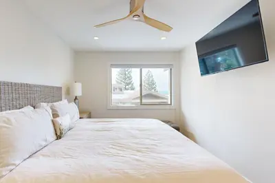 a bedroom with a bed with a ceiling fan and a window at Towering Pine in Incline in Incline Village