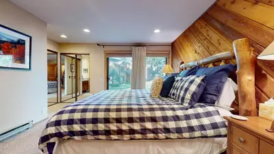 a bedroom with a large bed with a wooden wall at Snowcreek I #47 condo in Mammoth Lakes