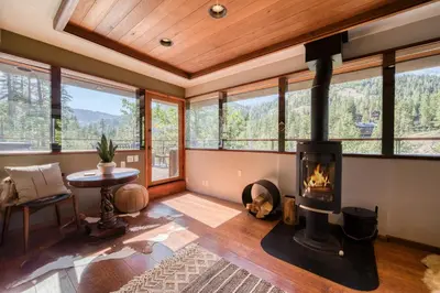 a living room with a wood stove in a house at Spire Chalet at Alpine Meadows - 4BR W Hot Tub and Ski Shuttle in Alpine Meadows