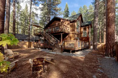 a large log cabin in the woods with a staircase at Kings Beach Retreat, Hot Tub, Walk to Beach in Kings Beach