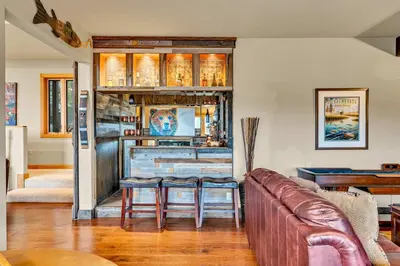 a living room with a couch and two stools at Secluded Tahoe Retreat by Northstar with Hot Tub in Truckee