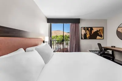 a hotel room with a large bed and a desk at The Federal Hotel Downtown Carson City, an Ascend Collection Hotel in Carson City