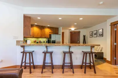 a kitchen with a bar with stools at Iron Horse Lodge South 408 by East West Hospitality in Truckee