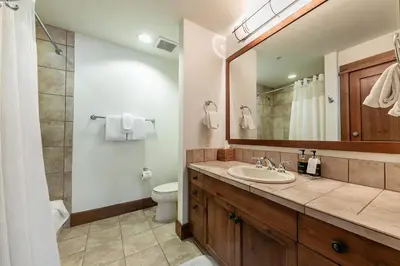 a bathroom with a sink and a toilet and a mirror at Iron Horse Lodge South 408 by East West Hospitality in Truckee
