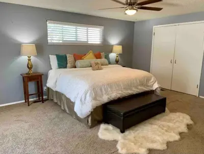 a bedroom with a large bed and a ceiling fan at Midtown Old Southwest Home With Pool! in Reno