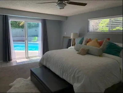 a bedroom with a large bed with a view of a pool at Midtown Old Southwest Home With Pool! in Reno