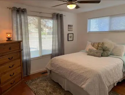 a bedroom with a bed and a dresser and a window at Midtown Old Southwest Home With Pool! in Reno