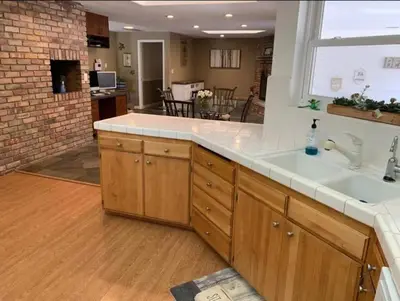 a kitchen with a sink and a living room at Midtown Old Southwest Home With Pool! in Reno