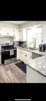 a kitchen with white cabinets and a black stove at Beautiful Home & Pool in Fresno