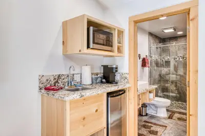 a small kitchen with a sink and a toilet at Cottage Like Suite with Private Hot Tub in Bass Lake