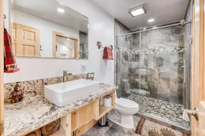 a bathroom with a sink and a shower at Cottage Like Suite with Private Hot Tub in Bass Lake