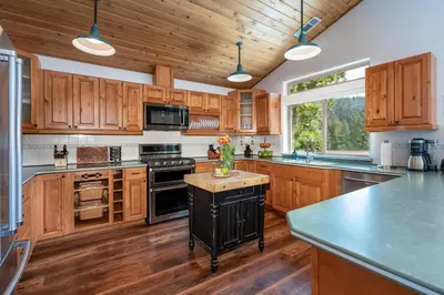 a kitchen with wooden cabinets and a center island with a vase of flowers at Yosemite Summit & Little Summit in Yosemite West