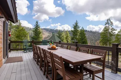 a wooden deck with a wooden table and chairs at Yosemite Summit & Little Summit in Yosemite West