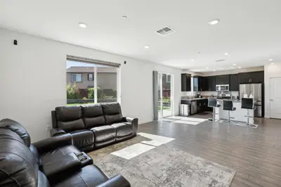 a living room with a leather couch and a kitchen at Spacious 3BR Home with Charming Backyard home in Folsom