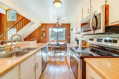 a kitchen with wooden cabinets and a staircase at 5 Mi to Northstar Skiing Bear Den Home with Decks in Kings Beach