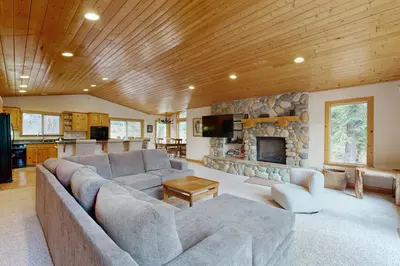 a living room with a couch and a stone fireplace at Vista Pines Retreat in Tahoe Vista