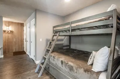 a bunk bed with a ladder in a room at Crestview Bldg A #49 - Spacious 2 Bedroom, 2 Bathroom, Sleeps 7 - Close to Canyon Lodge and Village in Mammoth Lakes