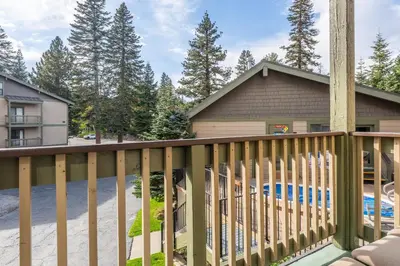 a house with a wooden deck with a swimming pool at Crestview Bldg A #49 - Spacious 2 Bedroom, 2 Bathroom, Sleeps 7 - Close to Canyon Lodge and Village in Mammoth Lakes