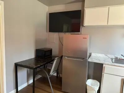 a small kitchen with a table and a refrigerator at Coalinga Motel in Coalinga