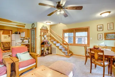 a living room with a ceiling fan and a spiral staircase at 1 Mi to Lake Tahoe Rustic Cabin with Boat Dock in Tahoma