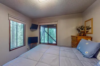 a bedroom with a large bed and a window at Tranquil Pines Retreat in Shaver Lake