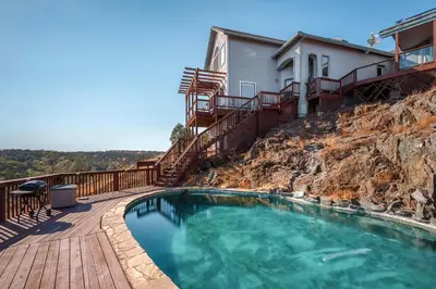 a swimming pool on a deck next to a house at Breathtaking view of the Hills with HotTub, Pool and Pool Table in Marble Mountain