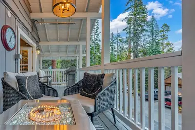 a patio with a table and chairs on a balcony at Modern Tahoe Retreat with Grill Walk to Beach in Homewood