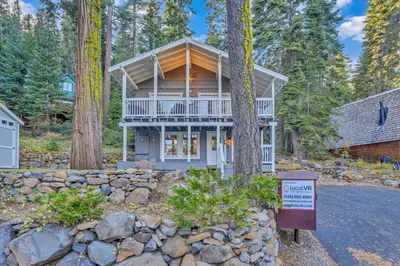 a house in the woods with a sign in front of it at Modern Tahoe Retreat with Grill Walk to Beach in Homewood