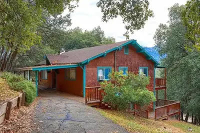 a red brick house with a blue roof at Mountain Dimension in Ponderosa Basin
