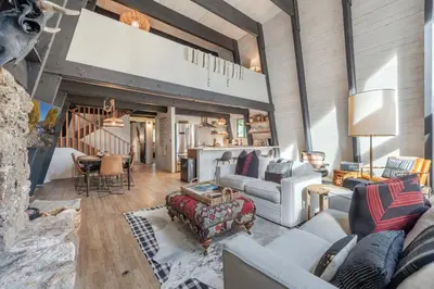 a living room with couches and a table at Mid Century Modern A-Frame Cabin at Northstar in Truckee