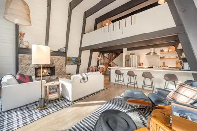 a living room with a couch and a fireplace at Mid Century Modern A-Frame Cabin at Northstar in Truckee